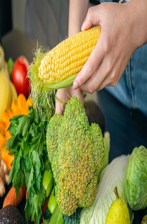 closeup-corn-female-hands-other-vegetables-kitchen-table-1